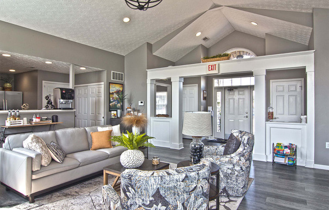 A living room with a grey couch and a grey and white patterned chair.
