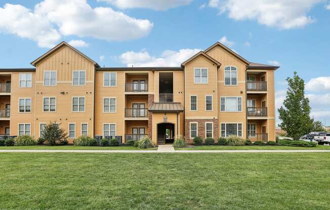 a large apartment building with a green lawn