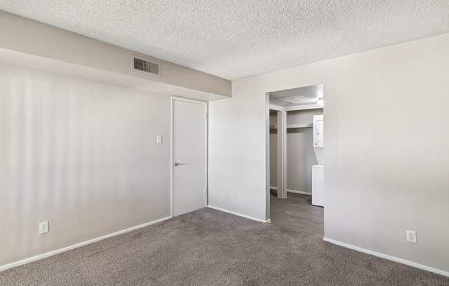 an empty living room with white walls and a carpeted floor