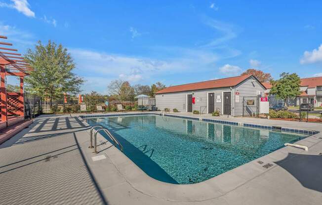 A large outdoor swimming pool with a red structure on the left side.