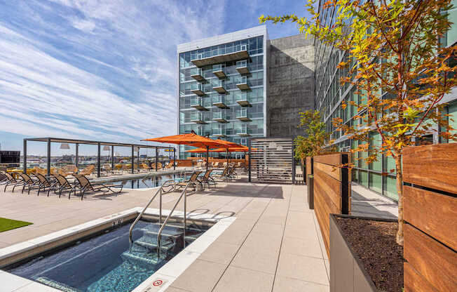 A modern pool area with a glass building in the background.