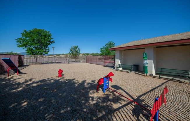two red fire hydrants in a fenced in play area with a building