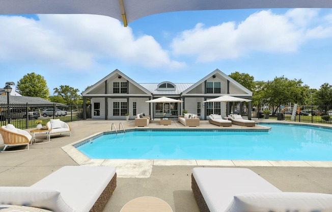 A large house with a pool in front.