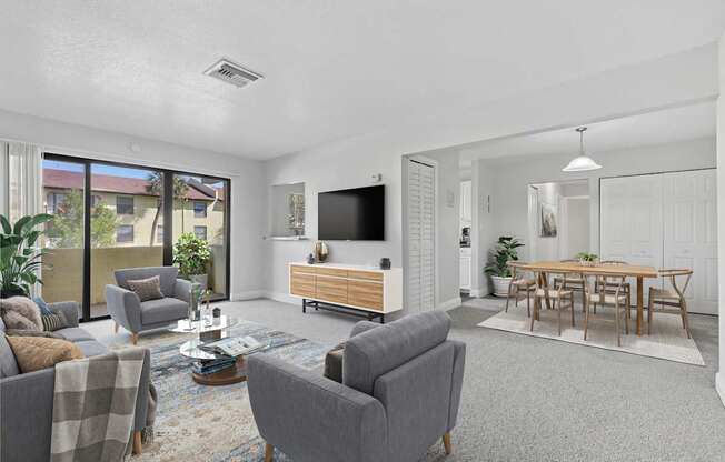 A living room with grey couches and a wooden entertainment center.