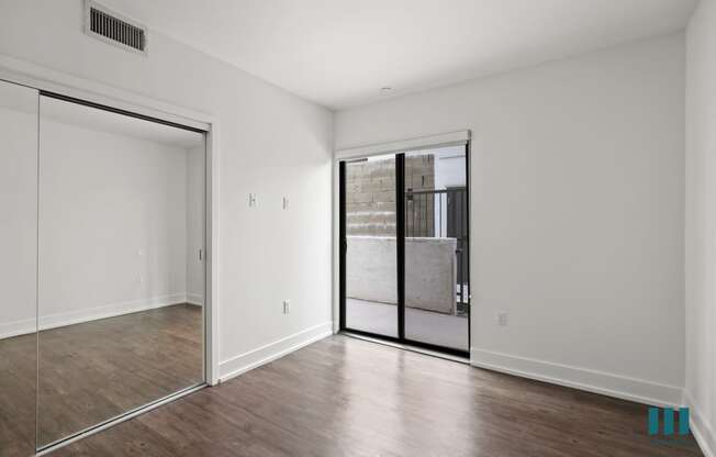 Bedroom with Balcony Access and Mirrored Closet