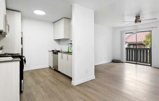 A kitchen with white cabinets and a wooden floor.