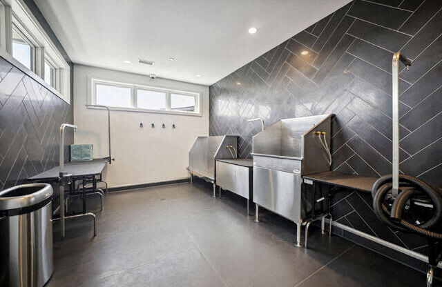 a kitchen with three stainless steel refrigerators and a table