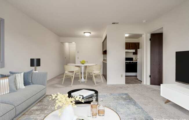 a living room with a couch and a table in front of a tv at The Landings Apartments, Westland at The Landings Apartments, Michigan