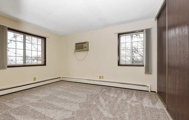 Fridley, MN Georgetown Apartments. A bedroom with two windows and a carpeted floor