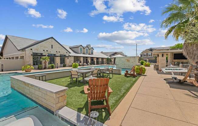 A sunny day at a poolside with a chair and a house in the background.