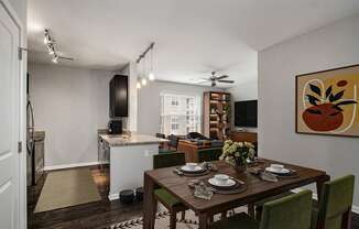 A dining room with a table set for a meal.