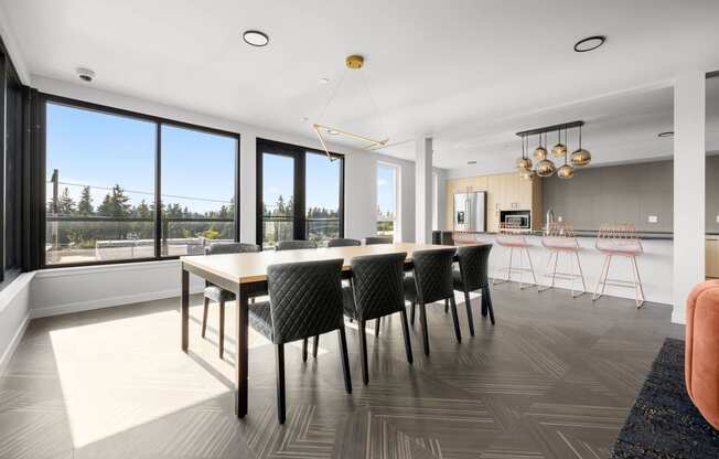 a dining room with a long wooden table and black and white chairs at Ion Town Center, Shoreline, 98133