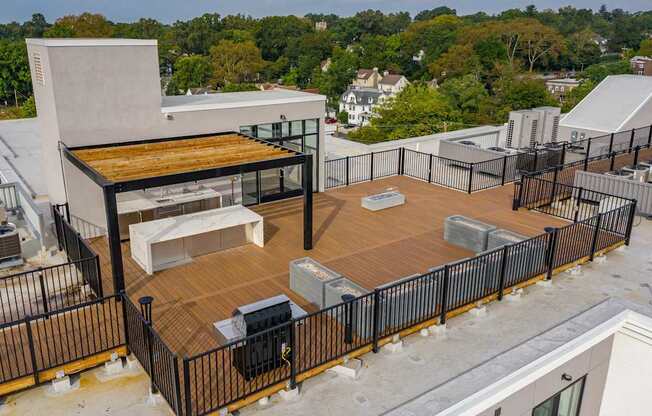 A rooftop patio with a grill and seating area.