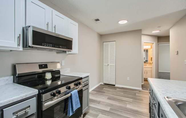 A kitchen with a stove top oven and microwave above it.