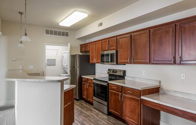 a modern kitchen with stainless steel appliances and wooden cabinets