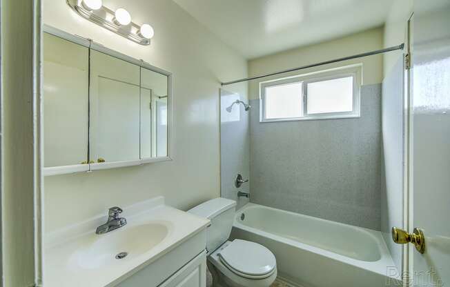 a bathroom with a white sink and toilet next to a white bathtub with a shower curtain at Terrace View Apartments, Daly City, 94015