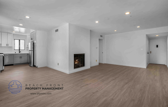 a living room with a fireplace and a kitchen with a stove and refrigerator