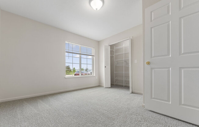 spacious bedroom with a closet and a window at Hunters Pond Apartment Homes, Champaign, IL