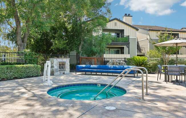 a swimming pool with a hot tub and an apartment in the background