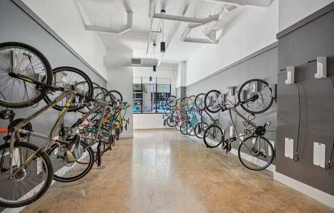 a row of bikes hanging on a wall in a room at Link Apartments® 4th Street, Winston-Salem, NC, 27101