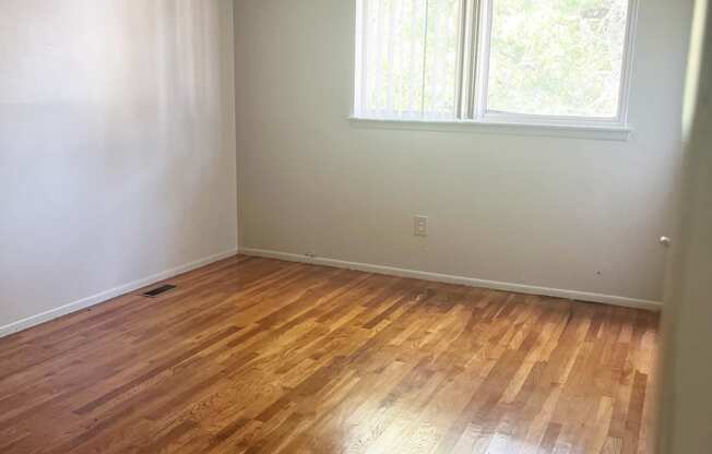 The Primary bedroom with a window and wooden floors