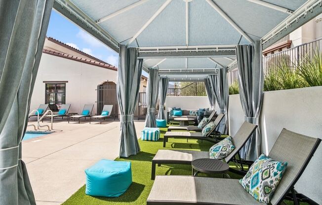 a patio with lounge chairs and tables and a pool at Arrive Temecula
