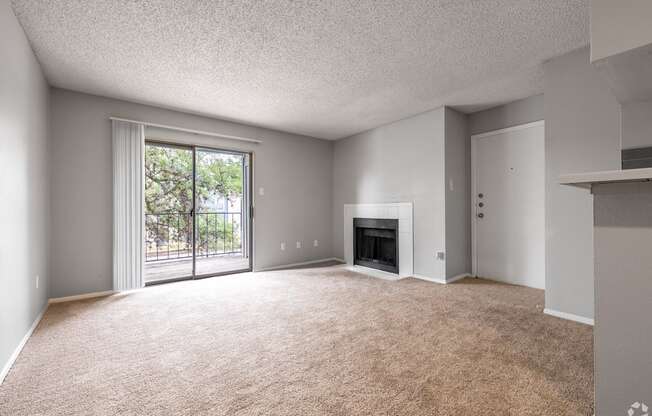 A spacious living room with a fireplace and sliding glass doors.