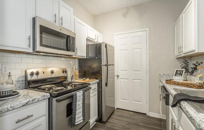 a kitchen with stainless steel appliances and white cabinets