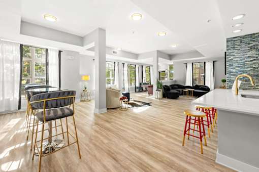 A modern living room with a bar area and a kitchen in the background.