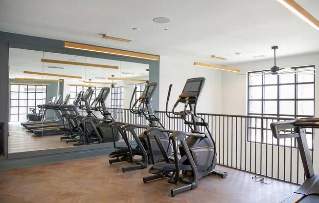 Second-story cardio area with modern elliptical machines at Novel Cary