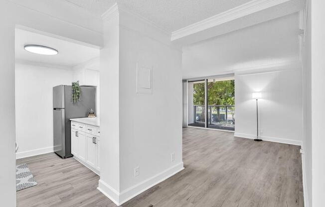 A kitchen with white cabinets and a fridge is shown.