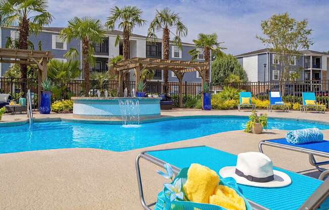 a swimming pool with a hat and some chairs around it