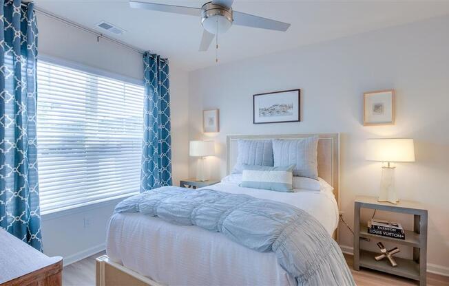 Spacious furnished bedroom with 9ft ceilings and window with ample natural lighting at The Station at Savannah Quarters apartments for rent