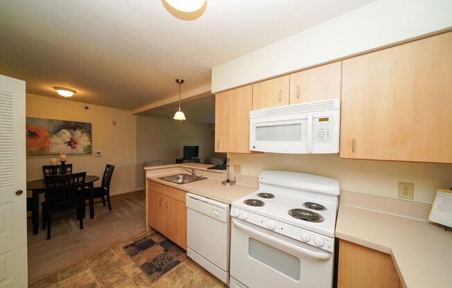 Maple Cabinetry and White Kitchen Appliances at Limestone Creek Apartment Homes, 35756