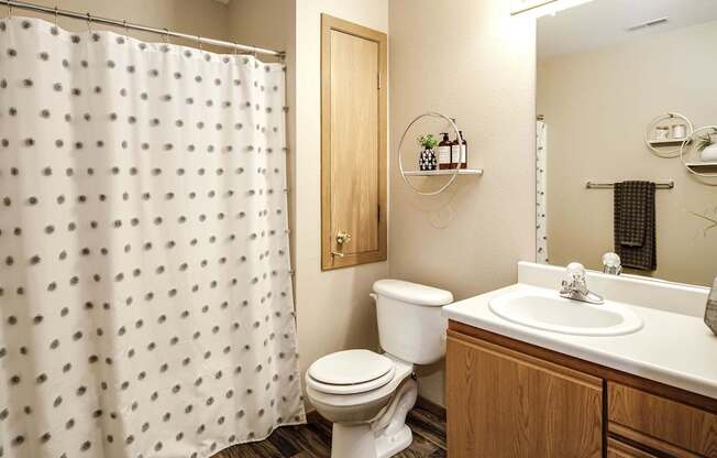 A white toilet sits next to a sink in a bathroom. at Tranquility Pointe, Omaha