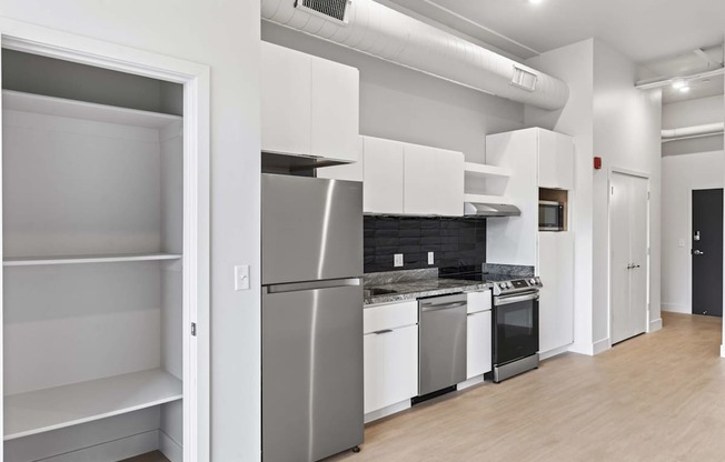 A kitchen with white appliances and cabinets. at Brickside Heights, Millcreek, 84106