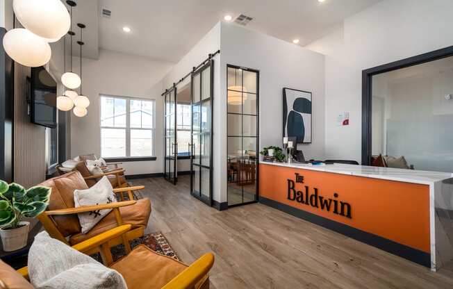 a living room with an orange desk and a kitchen