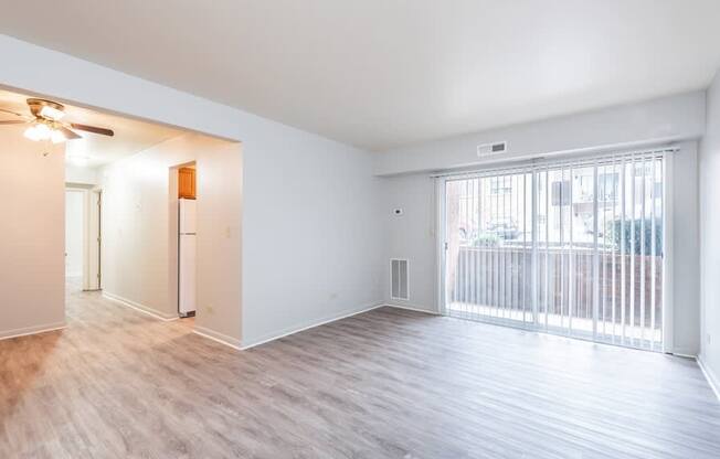 A spacious room with a sliding glass door leading to a balcony.