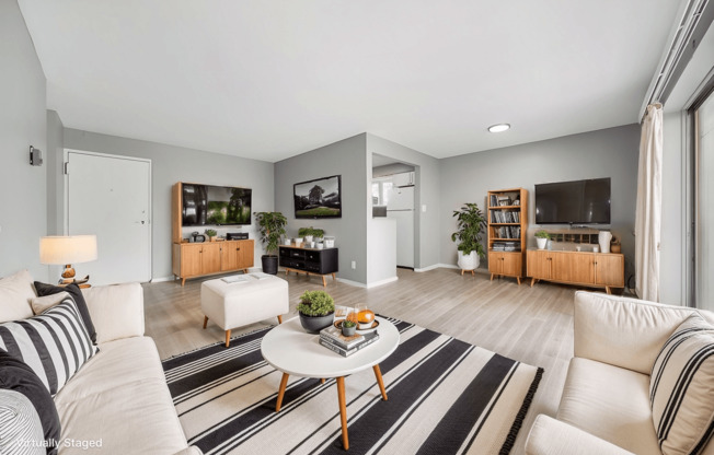 A living room with a white sofa, a coffee table, and a TV.