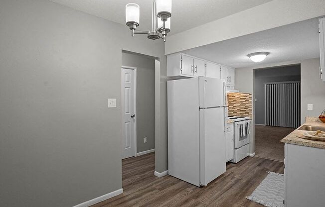 a kitchen with a white refrigerator and a stove
