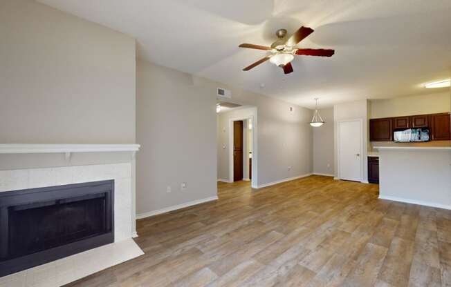 a living room with a fireplace and a ceiling fan