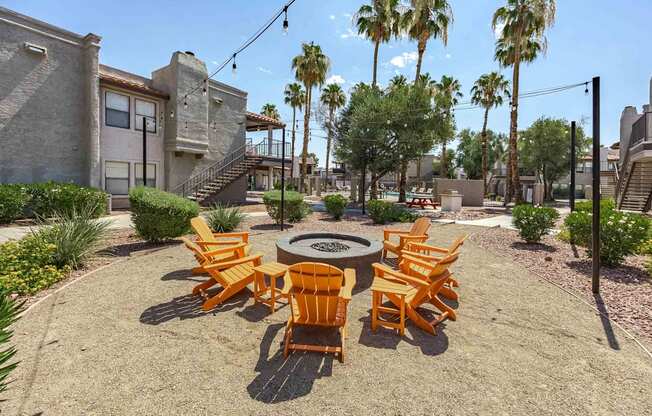 A patio with a fire pit and chairs.