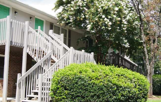 a house with white stairs and a green porch