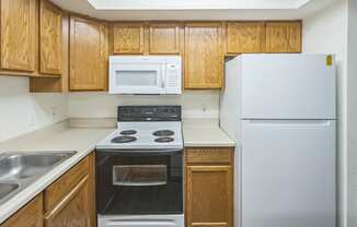 a kitchen with white appliances and wooden cabinets