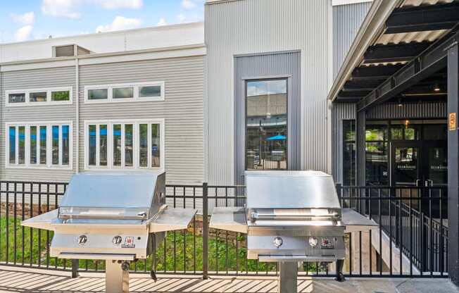 two bbq pits outside of a restaurant with a building in the background at The Tannery, Glastonbury