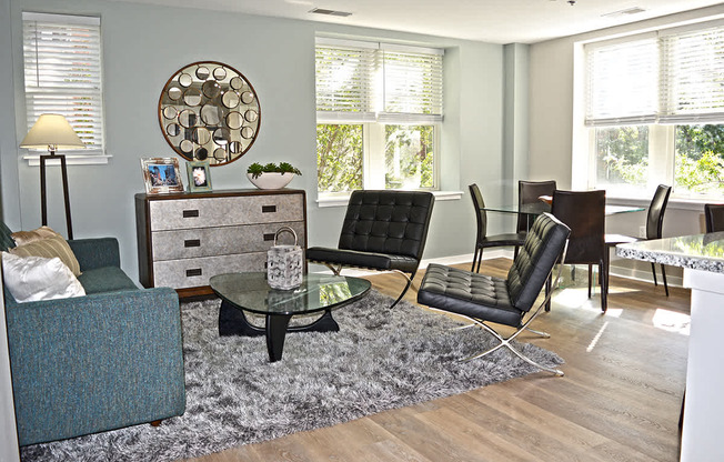 Living room with light wood floors, gray area rug, two chair and coffee table at Residences at Forest Park, Saint Louis, Missouri