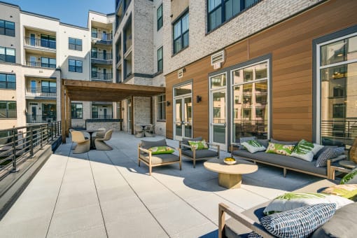 the private patio of an apartment building with furniture and a table