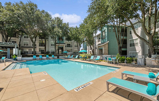 Community Swimming Pool with Pool Furniture at Essence Apartments in Dallas, TX.