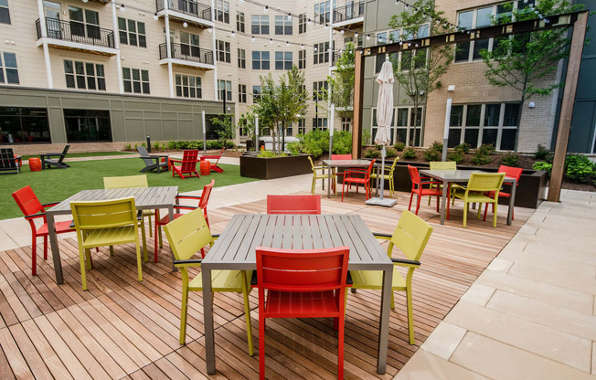 a large patio with tables and chairs and a building in the background