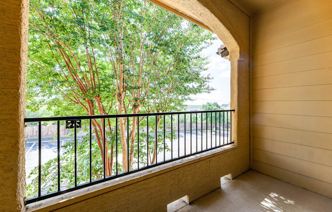 a balcony with a view of the trees and the river